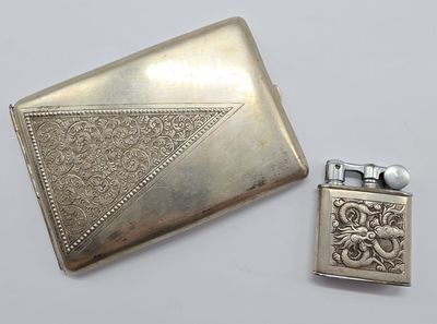 un étui à cigarettes ancien en argent et un briquet posés l'un à côté de l'autre