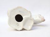 a white vase that has a black hole in it