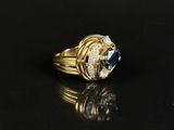 an image of a gold ring with a blue stone and diamonds