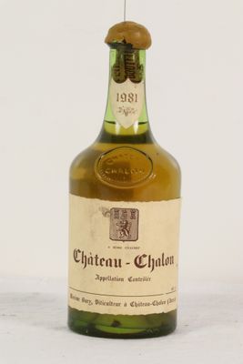une vieille bouteille de vin posée sur une table blanche