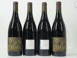 quatre bouteilles de vin sont alignées sur une surface blanche
