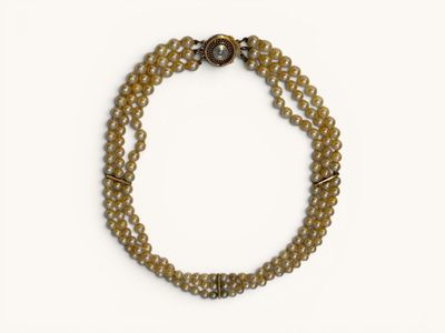 Gros plan sur un bracelet en perles posé sur une surface blanche