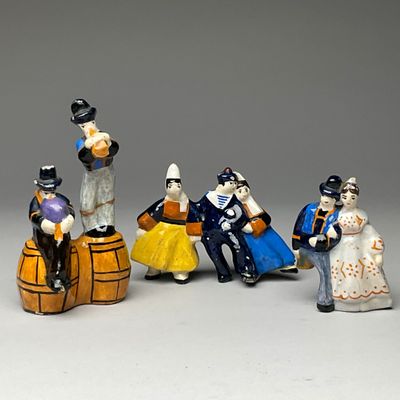 cinq figurines représentant des personnes assises sur un tonneau