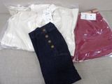deux pantalons et une chemise blanche posés sur un canapé