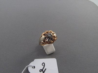une bague en or ornée d'une fleur et d'une étiquette de prix
