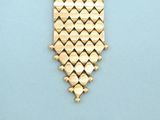 a close up of a gold bracelet on a blue surface