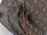 a close up of a brown louis vuitton bag on a white surface