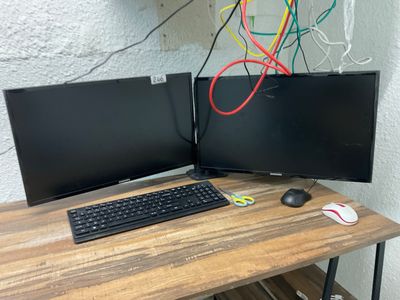 two computer monitors and a keyboard on a desk