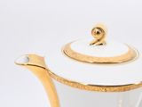 a white and gold tea pot with a gold rim