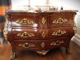 a marble top chest of drawers on a wooden floor