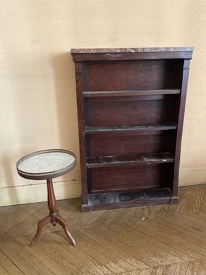 une petite table et une bibliothèque dans un coin de la pièce