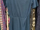 a blue dress hanging on a rack in a clothing store