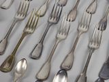 a lot of silver spoons and forks on the table