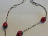 un gros plan d'un bracelet rouge et vert posé sur une surface blanche