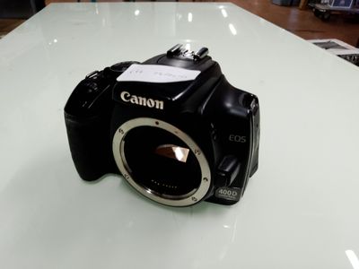 un appareil photo Canon posé sur une table en verre dans un magasin