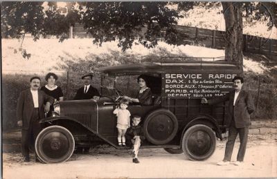 a black and white photo of a group of people standing in front of a truck