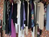 a rack of clothes in a room with a wallpapered wall