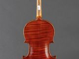 an antique violin on a stand with a black background