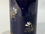 un vase bleu orné de motifs dorés et de fleurs
