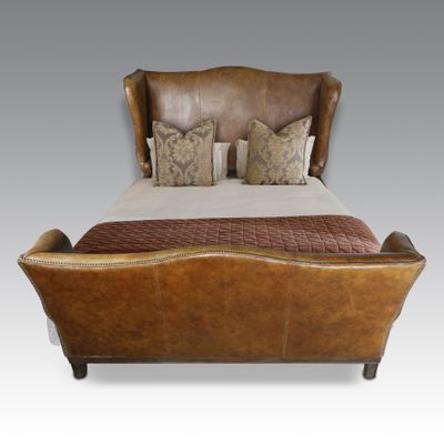 bed with brown leather headboard and foot board and pillows