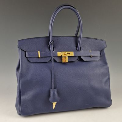 un sac à main en cuir bleu muni d'un fermoir doré sur la poignée
