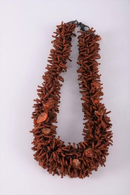a close up of a necklace on a white surface
