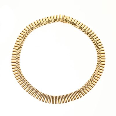gros plan d'un collier en or sur fond blanc