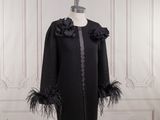 an image of a black coat with feathers on a mannequin