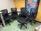 quatre chaises de bureau noires dans un coin de la pièce