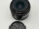 a close up of a camera lens on a white surface with a lens cap