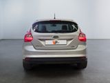 the back end of a silver car in a white room