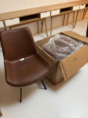 deux chaises et une table dans une pièce où se trouve un carton posé par terre