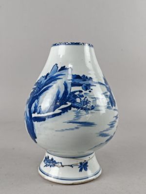 un vase bleu et blanc avec un oiseau dessus