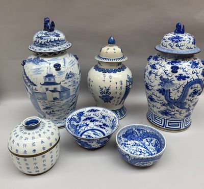 Plusieurs vases et bols bleus et blancs sont posés sur une table
