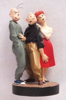 trois figurines représentant un homme et une femme posées sur une table