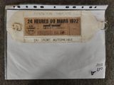 an envelope with a ticket attached to it sitting on a carpet