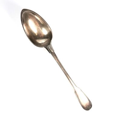 une cuillère en argent avec un manche de cuillère sur une surface blanche