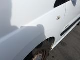 a white van parked in a parking lot with its door open