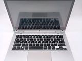 a silver laptop with a black keyboard on a white surface