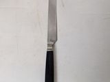 a knife that is laying on a white table