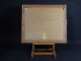 an old wooden easel with a painting on it against a black background