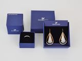 deux paires de boucles d'oreilles en argent et en or, présentées dans un coffret cadeau bleu