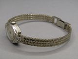 une photo d'un bracelet en argent sur lequel est posée une montre en argent