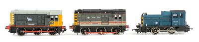 three toy trains sitting next to each other on a white surface