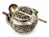 a silver teapot with a spoon and a spoon in it