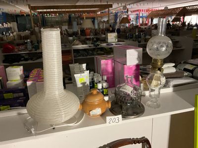 une table sur laquelle se trouvent une lampe, un vase et d'autres objets