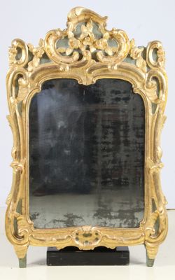 un miroir avec un cadre doré posé sur une table blanche