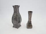 two vases sitting next to each other on a white surface