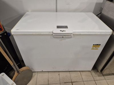 a white refrigerator sitting in a kitchen next to a trash can