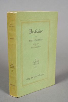 an old book sitting on top of a table on a gray surface